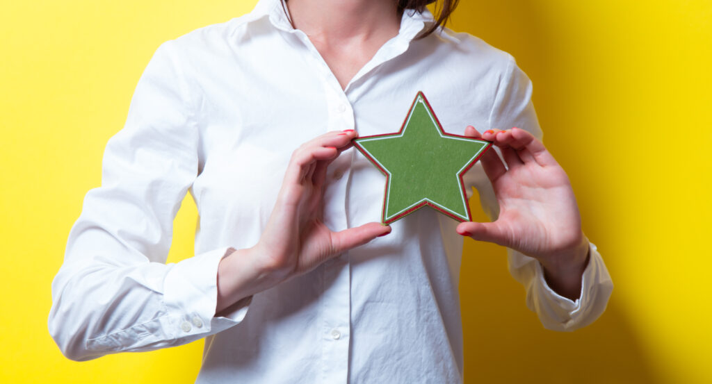photo of beautiful young woman with star shaped toy on the yellow background